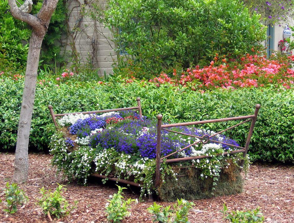 старая кровать для цветов на садовом участке 