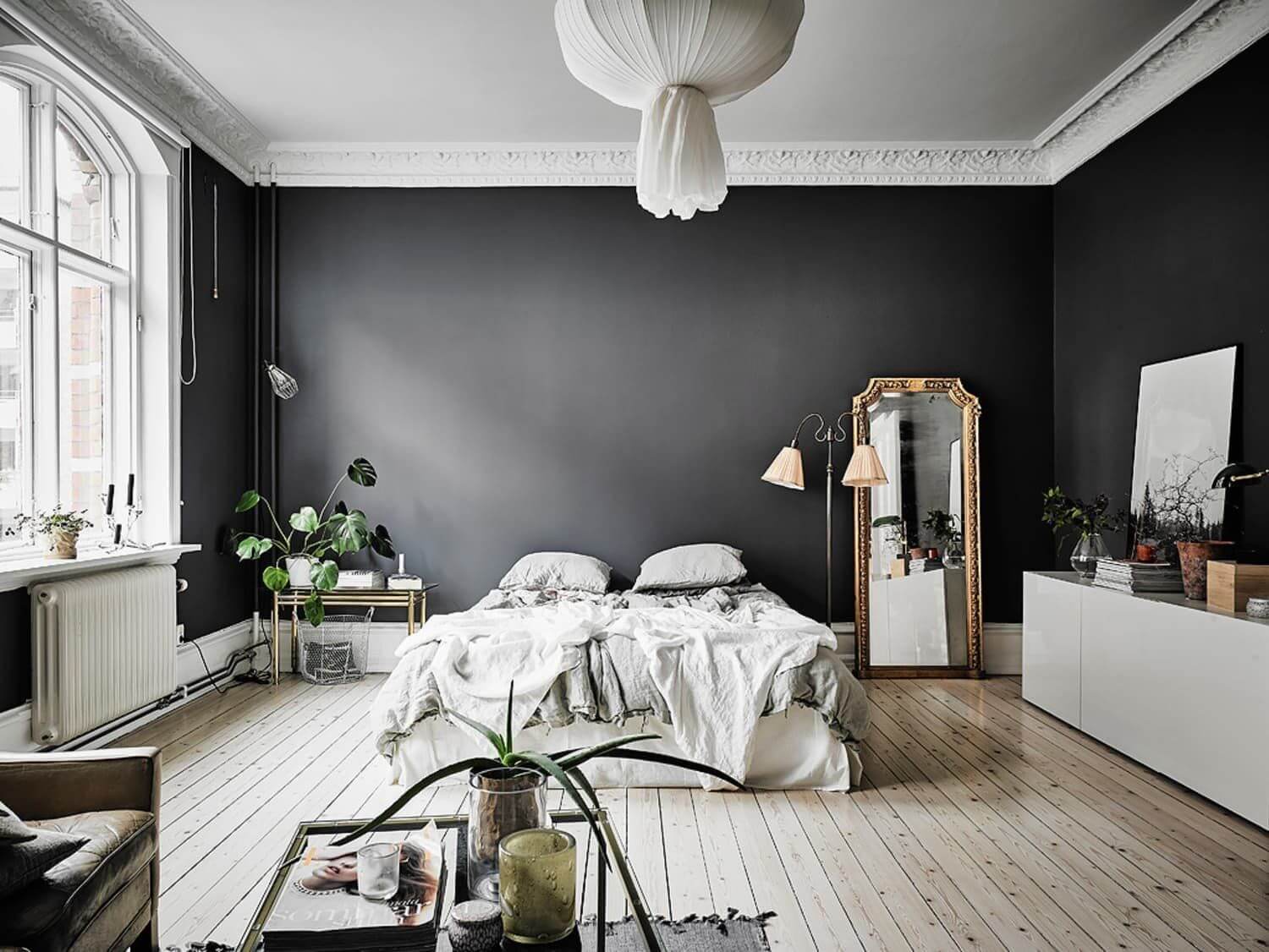 черные стены и деревянный пол в спальне